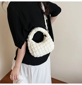 Detail of white quilted cloud bag featuring puff square texture and versatile shoulder strap