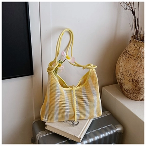 Detailed macro view of yellow and white striped mesh net bag with thin knotted handles
