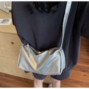 Silberne Umhängetasche in Kissenform mit Metallic-Struktur an einem Frauenmodell