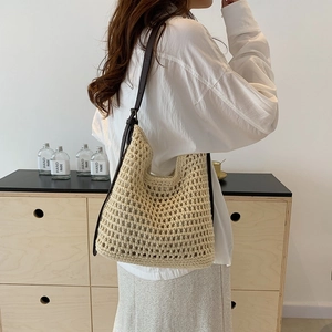 Detail of hand-woven crochet tote bag with premium brown leather strap on model