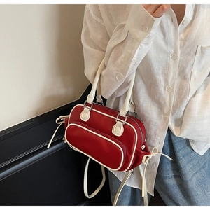 Detail of red and white vintage bowling bag featuring contrast trim and front zipper pocket