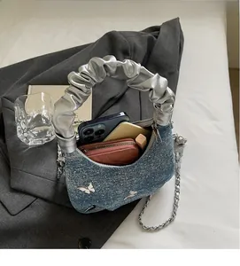 Mini borsa in denim blu che mostra lo spazio interno per telefono e portafoglio