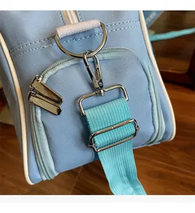 Close-up of light blue travel bag featuring cross-grain leather and silver metal D-ring