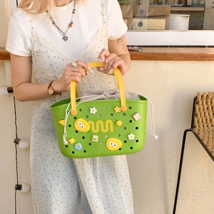 Detail of green EVA shower caddy with cartoon charms and gray drawstring inner bag