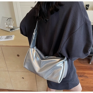 Detailansicht der glänzenden silbernen Metalltextur und des Reißverschlusses der Tasche