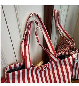 Close-up of red and white striped canvas tote bag showing button closure and knot detail