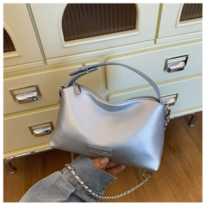 Detail showing metallic silver crossbody bag with sturdy handle and metal chain strap
