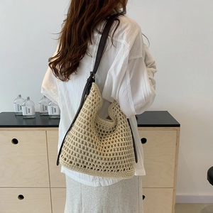 Detail of hand-woven beige crochet shoulder bag with premium dark brown leather straps