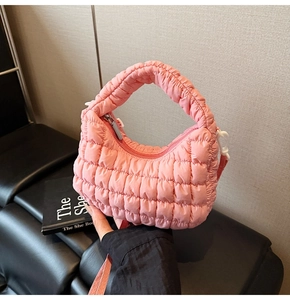 Close-up of pink quilted cloud bag featuring soft padded texture and crossbody strap