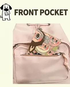 Detail of light pink nylon backpack featuring a front zipper pocket with a cartoon card inside