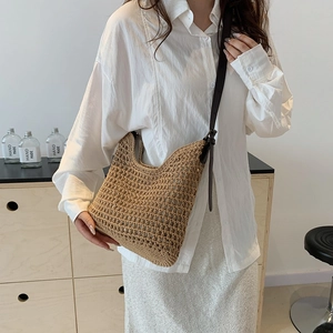 Detailed view of a brown crochet shoulder bag with hollow-out knit and leather strap