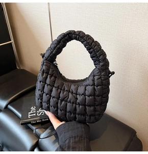 Macro detail of black quilted cloud bag showing soft nylon texture and pleated handle
