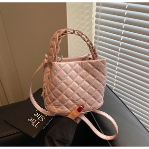 Dettaglio della borsa rosa trapuntata con cristalli e manico ad anello intrecciato