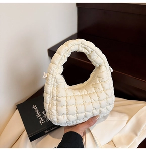Detail of off-white quilted cloud bag featuring soft padded fabric and high-quality stitching