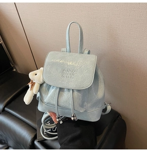 Detail of light blue pleated bucket backpack with drawstring and silver bead accents