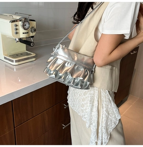 Detail of silver metallic ruffle crossbody bag with pleated finish and thin shoulder strap