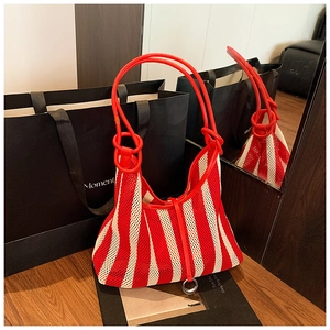 Detail of red and white striped mesh tote bag with tubular handles and metal ring