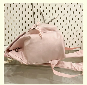 Side view detail of pink casual backpack showing drawstring closure and front zipper pocket
