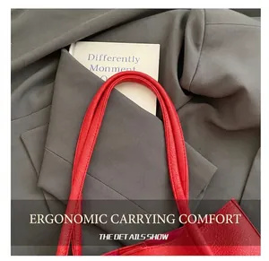 Close-up of red lychee textured leather tote bag showing handle craftsmanship and stitching