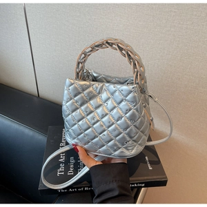 Close-up of silver quilted bucket bag with rhinestone embellishments and woven handle