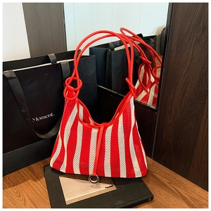 Detail of red and white striped knit mesh bag with leather handles and metallic ring