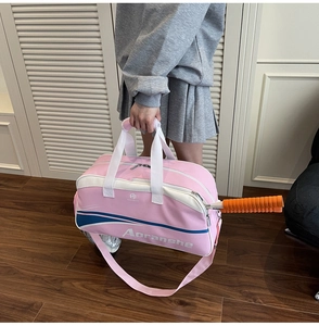 Pink sports gym bag with tennis racket compartment and adjustable shoulder strap detail