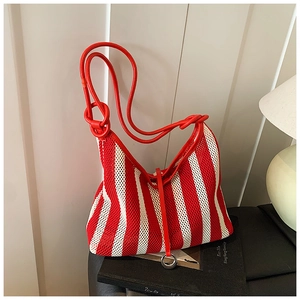 Detail of red and white striped mesh woven bag with tubular strap and metal ring