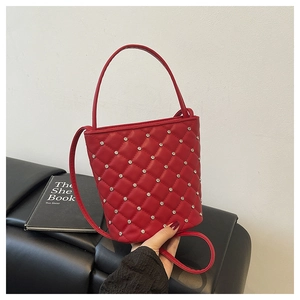 Dettaglio ravvicinato di una borsa a secchiello trapuntata rossa con strass argentati