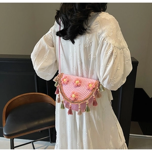 Detailed back view of pink woven bucket bag with 3D floral accents and colorful tassels