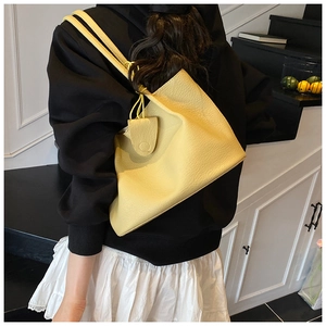 Detail of light yellow lychee pattern tote bag with shoulder strap and charm