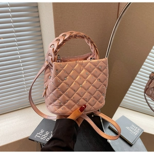 Dettaglio borsa a secchiello rosa trapuntata con strass e manico intrecciato