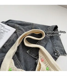 Detail of crochet tote bag strap with colorful beads on blue denim background