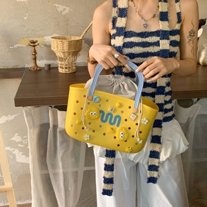 Close-up of yellow EVA tote with light blue handles and decorative DIY charms on bag