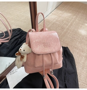 Pink pleated leather mini bucket backpack featuring a cute white teddy bear charm accessory