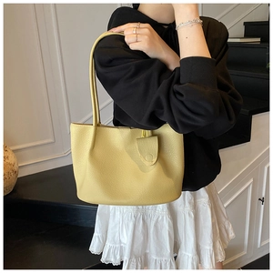 Detail showing the lychee pattern PU leather and magnetic clasp of the yellow tote bag
