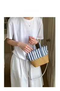 Detail of blue and white striped canvas and straw tote bag with detachable shoulder strap