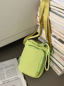 Neon green nylon crossbody bag with drawstring closure and adjustable shoulder strap