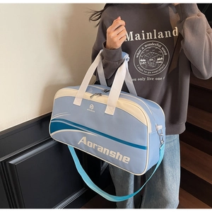 Close-up of blue and off-white travel gym bag featuring adjustable strap and logo