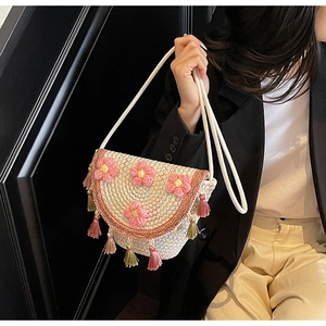 Detail of bohemian bucket bag with pink crochet flowers and colorful tassels charm