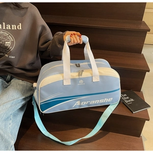 Detail of light blue sports bag with white handles and adjustable shoulder strap