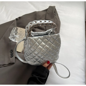 Dettaglio della borsa argento metallizzato con trapuntatura a rombi e decorazioni in cristallo