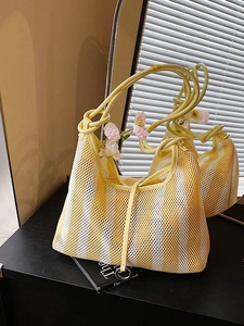 Bright yellow and white striped mesh tote bag with knotted handle and metal ring detail