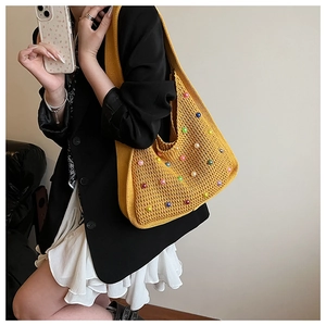 Detail of yellow knit tote bag featuring vibrant colorful pearl bead embellishments