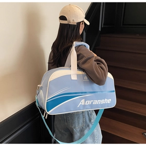 Side view of light blue fitness bag with logo and detachable shoulder strap on steps