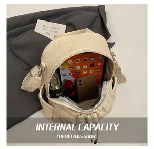 Top view of large beige leather backpack interior showing high capacity for tablets