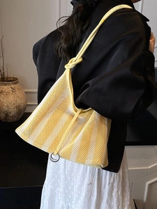 Hollow mesh tote bag with yellow stripes, knotted rope handle and silver ring detail