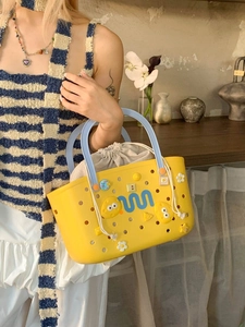 Yellow EVA beach tote bag with cute cartoon charms and blue handles for summer travel