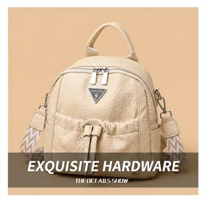 Detail of beige lychee grain leather backpack featuring dual silver zippers and metal logo