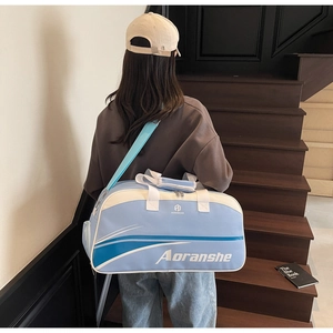 Detailed back view of a light blue and white sports travel bag with adjustable strap
