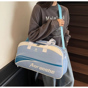 Detail of light blue and beige gym bag featuring adjustable strap and brand logo